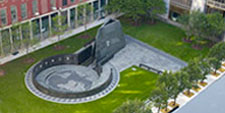 Sculpture or art installation in the green-grass courtyard of a surrounding building