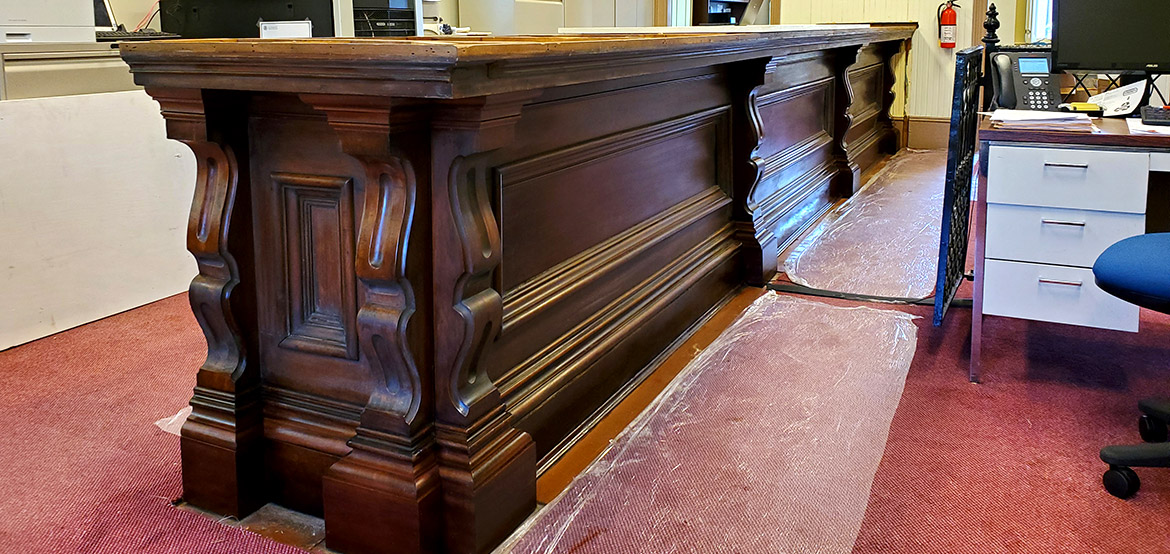Restored historical wood counter in a room with red carpet in the New Bedford Federal Building