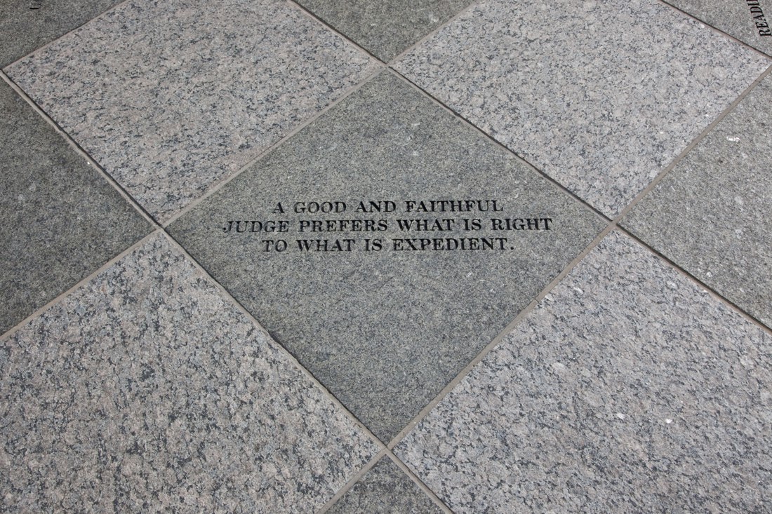 Inscribed stone tile stating 'A good and faithful judge prefers what is right to what is expedient'.