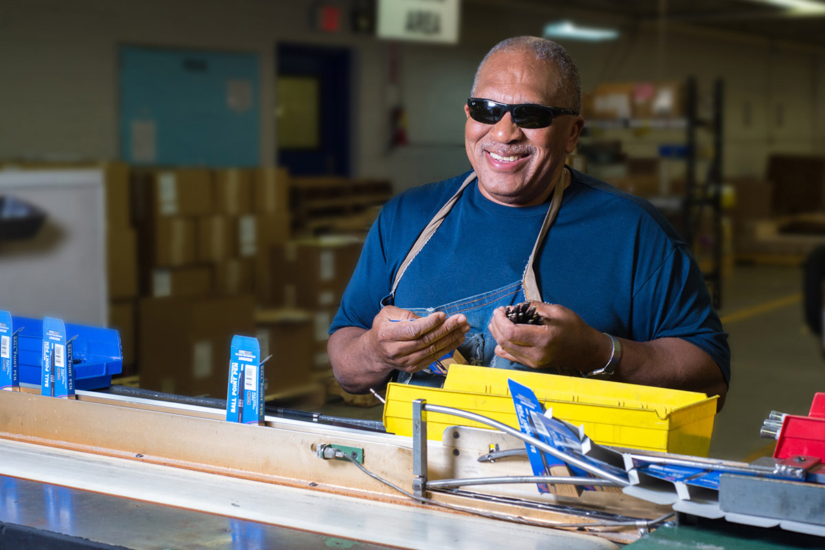 Man with sunglasses working in a factory assembly line