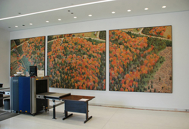Three paneled art of fall colored trees on a wall