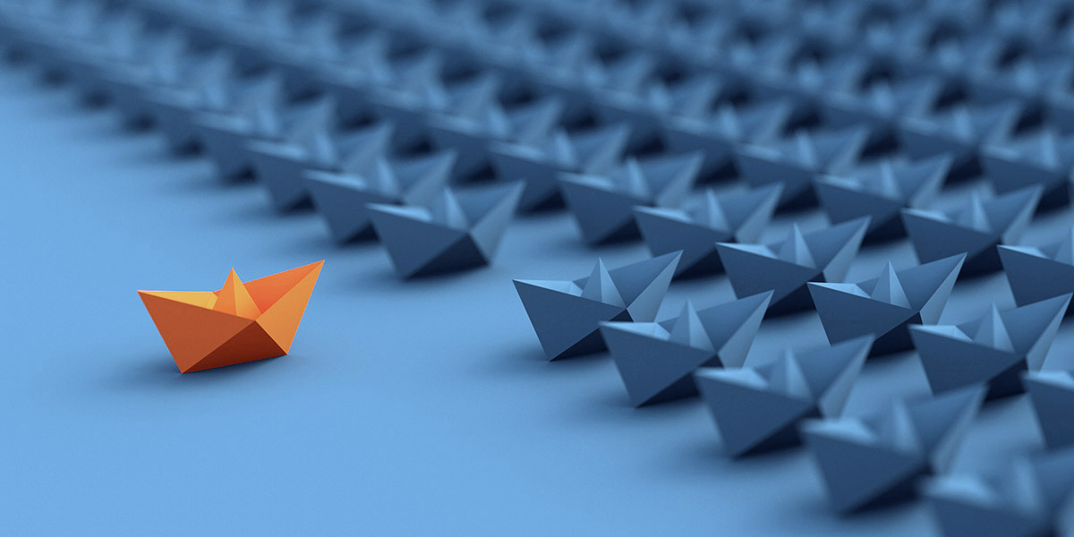 A sea of paper ships in alignment, with one orange one pulling ahead