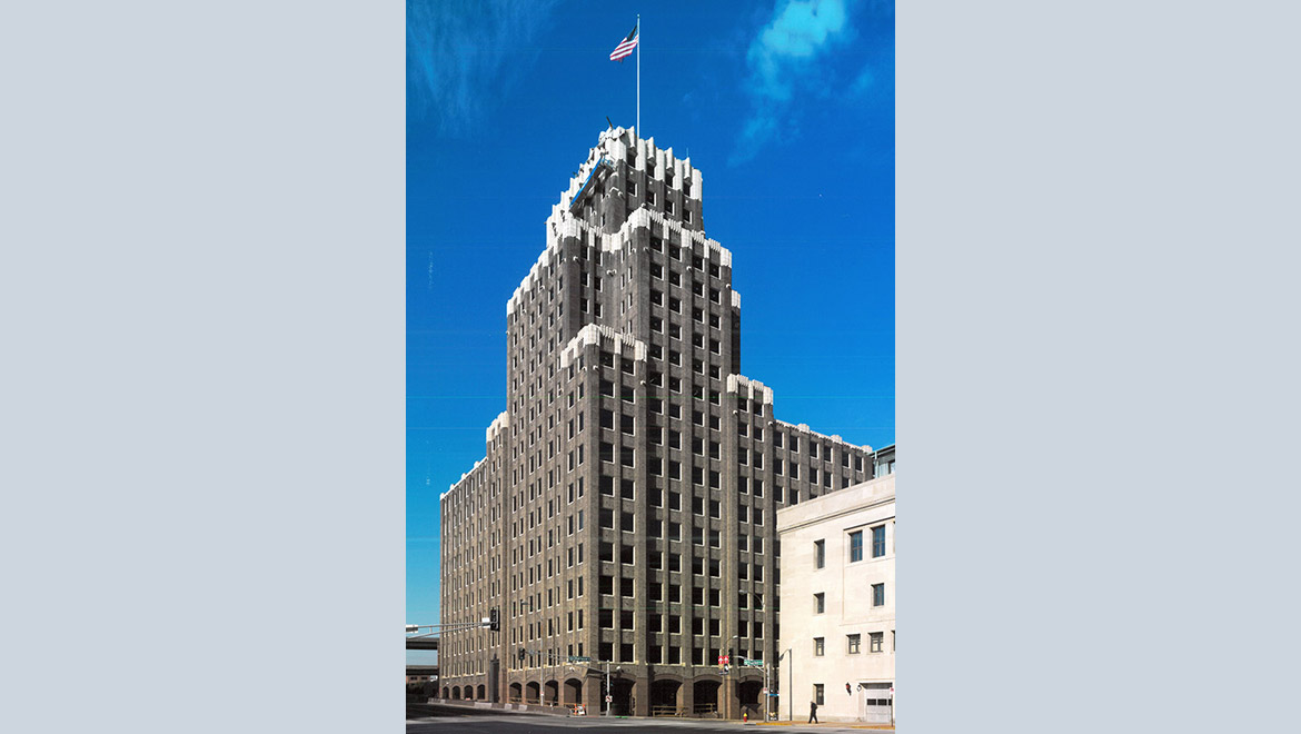 Two sides of a 20-story brick building with smaller towers stacked halfway up.