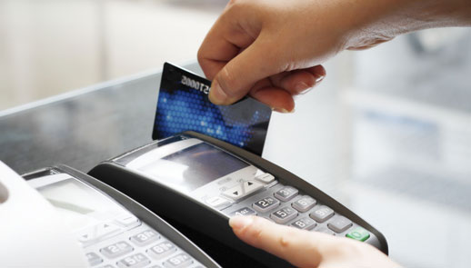 Photo of a credit card being swiped in a card scanner