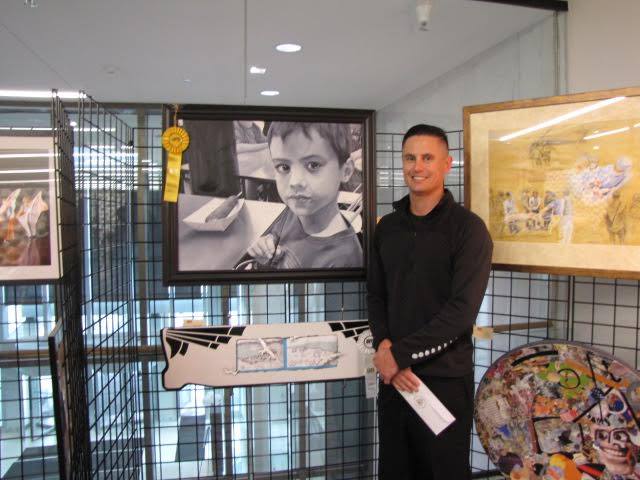 2015 Art Winner standing by his work of art