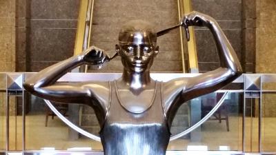 Sculpture of woman blindfolding herself as a symbol of justice at the Warren B. Rudman Courthouse in Concord, NH Sculpture of woman blindfolding herself as a symbol of justice at the Warren B. Rudman Courthouse in Concord, NH