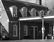 Exterior of building featuring the roof, with 4 gable style windows protruding from it. The roof above each window is peaked.