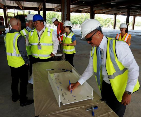 GSA Caribbean Field Office Manager Edgar Hernandez signs a piece of steel to represent the final framework of the new San Juan FBI complex May 30 in Hato Rey, Puerto Rico. (Photo by Mike Hogg)
