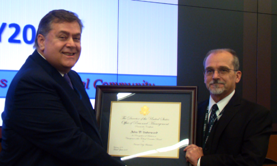 Newly inducted Greater Kansas City FEB Chairman Michael Copeland presents outgoing Chairman John Underwood with an award.