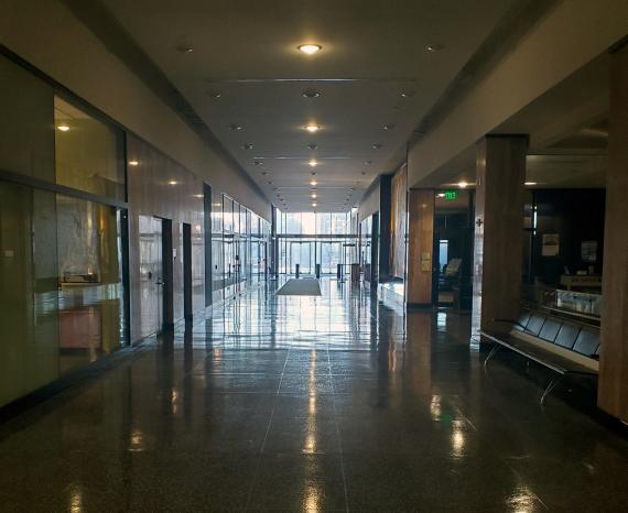 Photo of a main building hallway with lights reduced and no occupants.