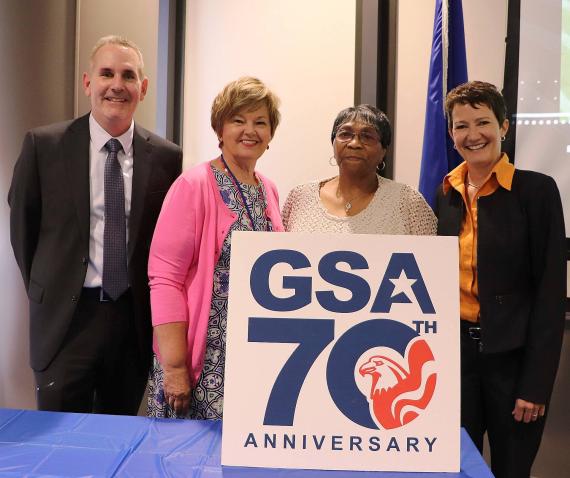 Kevin Rothmier, Judy Dungan, and Mary Ruwwe pose for a photo with Gwen Smith, GSA's longest-serving employee in Region 6.