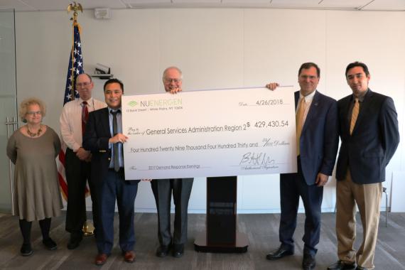 Employees pose for photo with ceremonial check