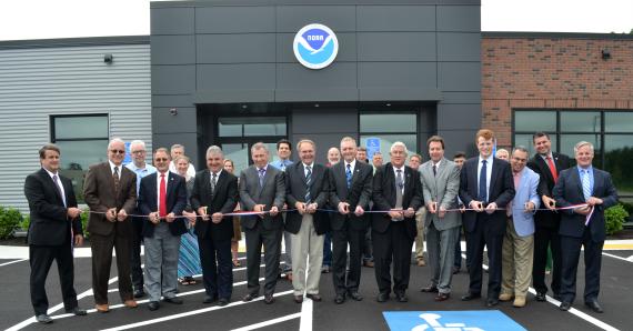 Government officials cut ribbon to celebrate new NOAA forecast facility.