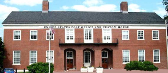 Red brick two-level building with text United States Post Office and Custom House above the windows