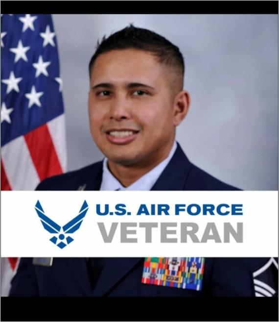 Victor Vorgsam, smiling, wearing a U.S. Air Force uniform and posing in front of a U.S. flag. A white banner across the picture reads: U.S. Air Force Veteran. 