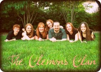Seven people lie in a prone position outdoors in grass with the text: The Clemons Clan