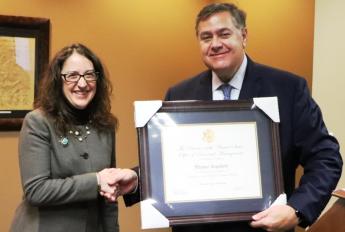Regina Heise presents Michael Copeland with a plaque from the Director of OPM.