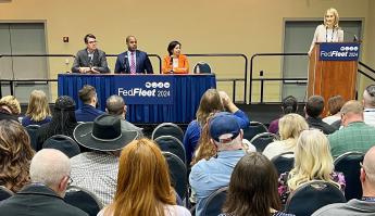 Three people sitting on a panel in front of a diverse audience