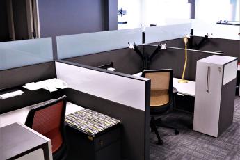 New office furniture in an office setting with cubicles, chairs, and desks