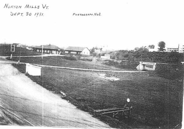 black and white photo of the road with railroad overpass