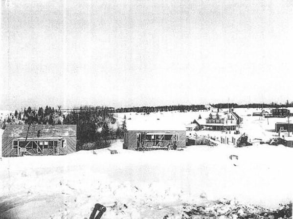black and white photo with 1931 residences in the background with an empty field in front of them