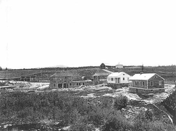 black and white photo of older building in the background that are now demolished