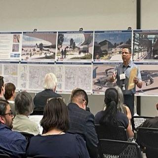 GSA Project Manager Speaking at Community Meeting with Project Renderings in background