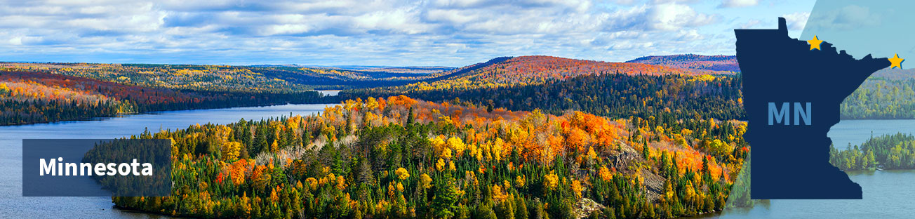 A forest and low hills of red and gold autumn trees and green pine trees as far as the eye can see, and blue lakes dotted throughout, with a blue cloudy sky, and the title Minnesota at left and at right the state shape with two gold stars along the northeast border
